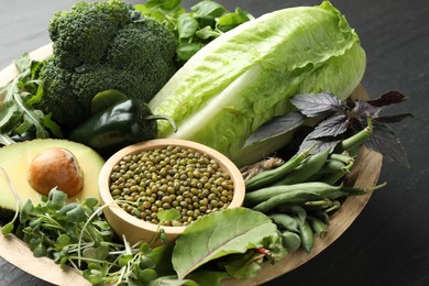 Photo of Superfood. Healthy food products in bowl on black table, closeup