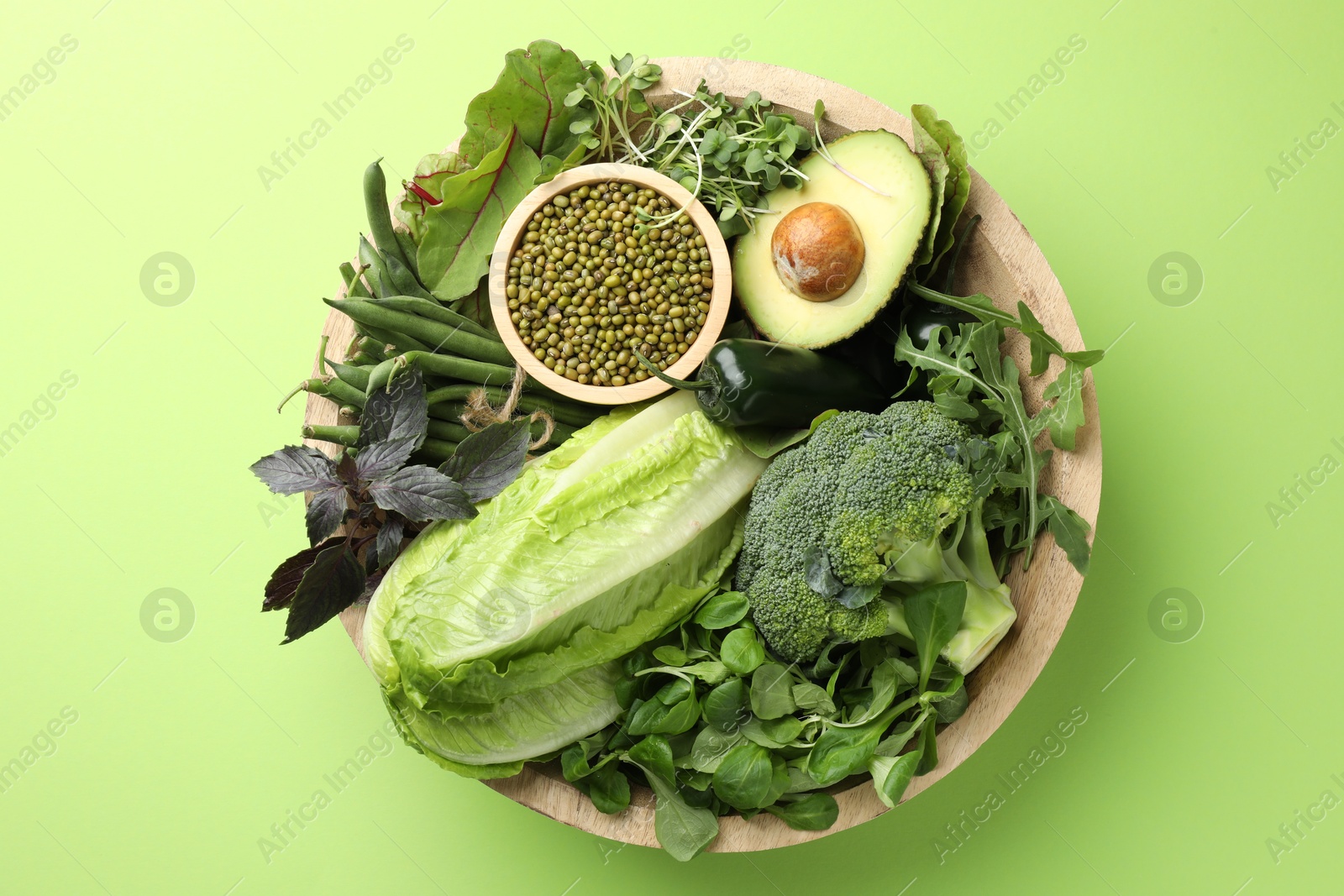 Superfood. Healthy food products in bowl on green background, top view Photo of Superfood. Healthy food products in bowl on green background, top view