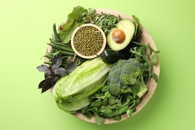 Photo of Superfood. Healthy food products in bowl on green background, top view