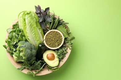 Photo of Superfood. Healthy food products in bowl on green background, top view. Space for text