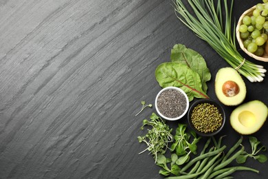 Photo of Superfood. Healthy food products on black table, flat lay. Space for text