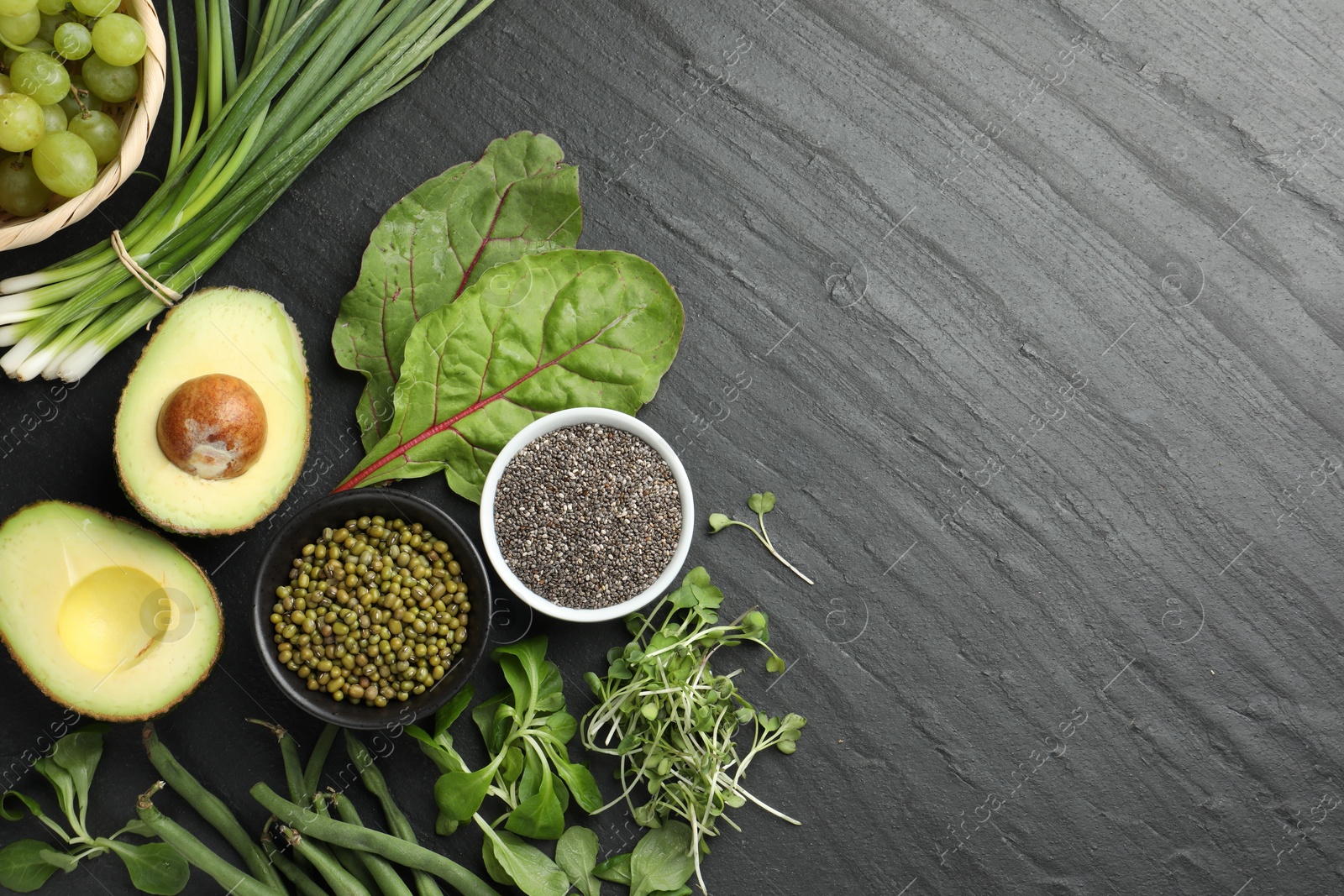 Photo of Superfood. Healthy food products on black table, flat lay. Space for text