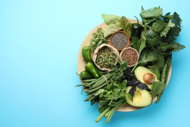Photo of Superfood. Healthy food products on light blue background, flat lay. Space for text