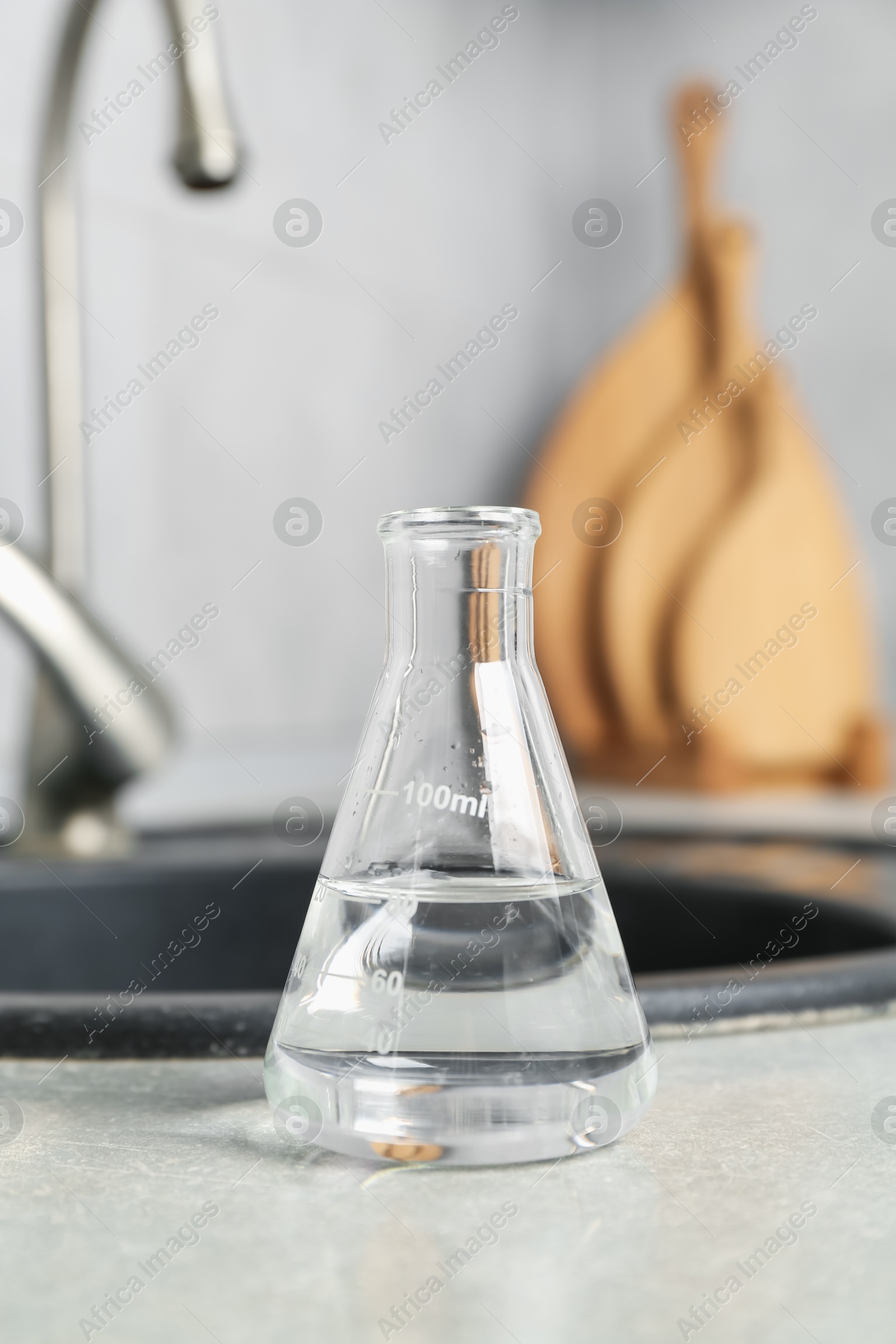 Flask with clean water near sink on counter in kitchen, closeup Photo of Flask with clean water near sink on counter in kitchen, closeup