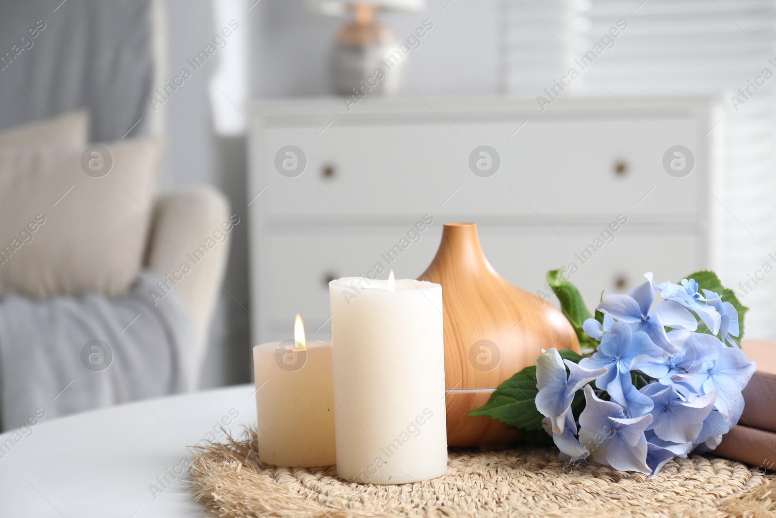 Spa composition with burning candles, aroma oil diffuser and flowers on white table indoors, closeup Photo of Spa composition with burning candles, aroma oil diffuser and flowers on white table indoors, closeup