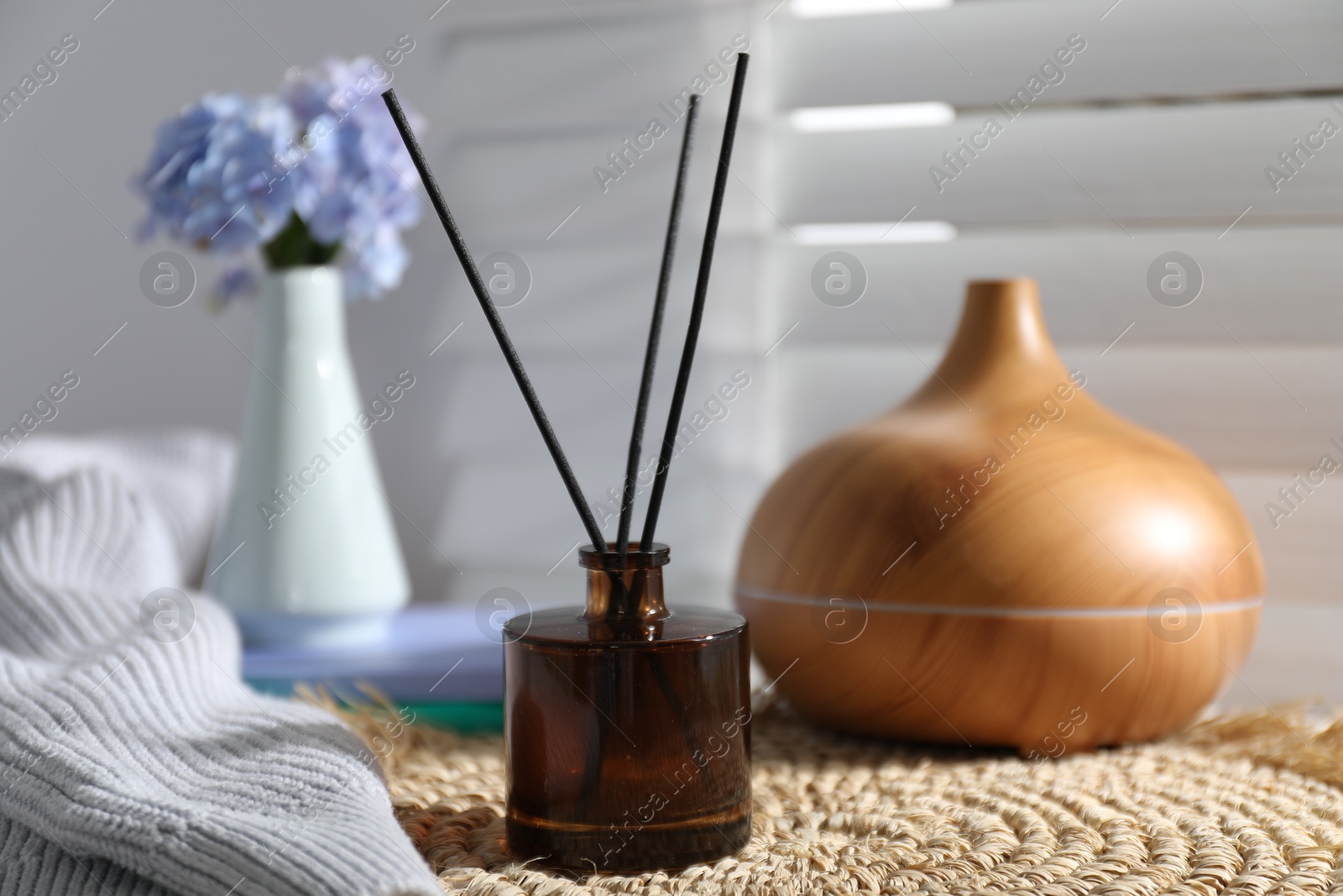 Spa composition with reed air freshener on wicker mat indoors, closeup Photo of Spa composition with reed air freshener on wicker mat indoors, closeup