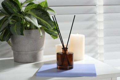 Photo of Spa composition with reed air freshener on white table indoors, closeup