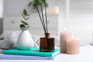 Photo of Spa composition with reed air freshener on white table indoors, closeup