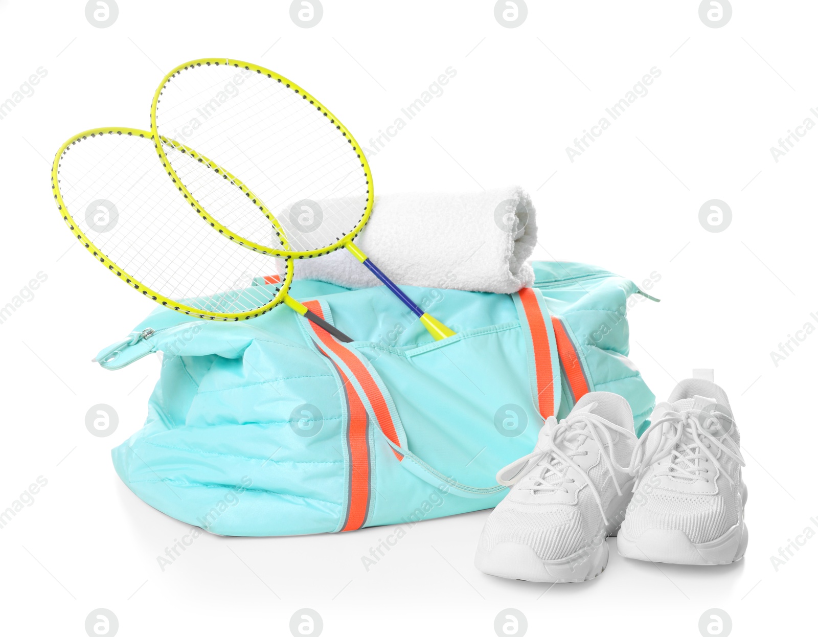 Photo of Stylish sports bag with badminton rackets, towel and sneakers isolated on white