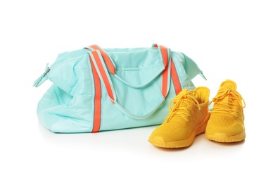 Photo of Stylish sports bag and sneakers isolated on white