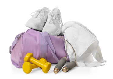 Photo of Stylish sports bag with sneakers, towel, skipping rope and dumbbells isolated on white