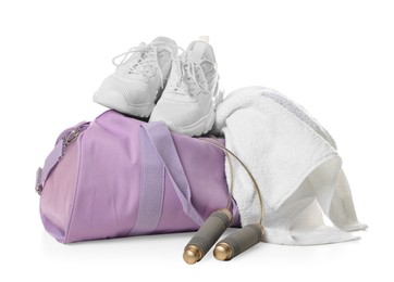 Photo of Stylish sports bag with sneakers, towel and skipping rope isolated on white