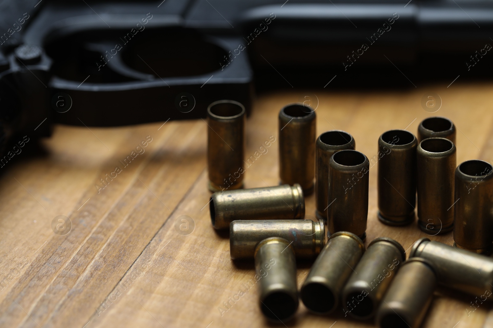 Bullets and gun on wooden table, closeup Photo of Bullets and gun on wooden table, closeup