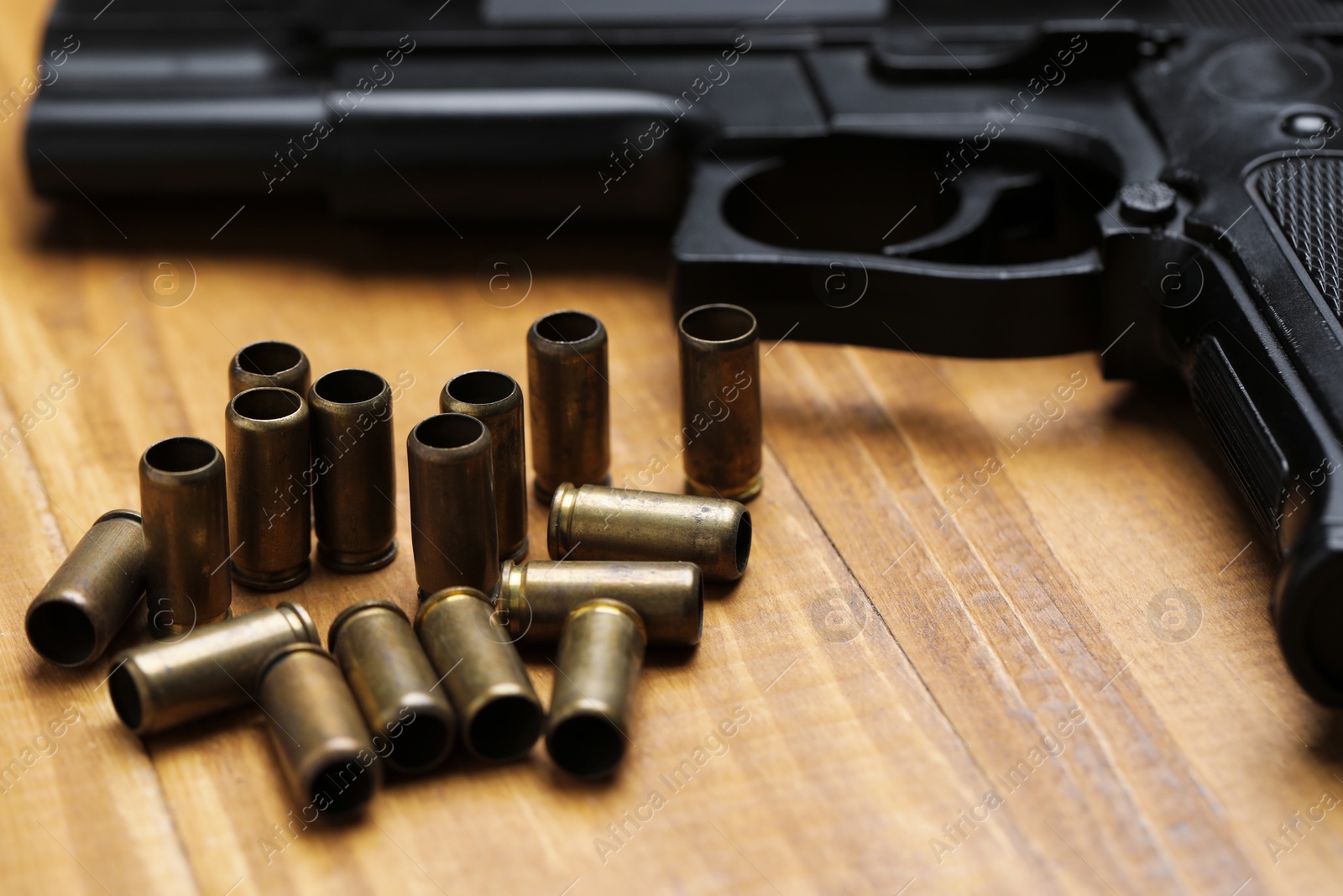 Bullets and gun on wooden table, closeup Photo of Bullets and gun on wooden table, closeup
