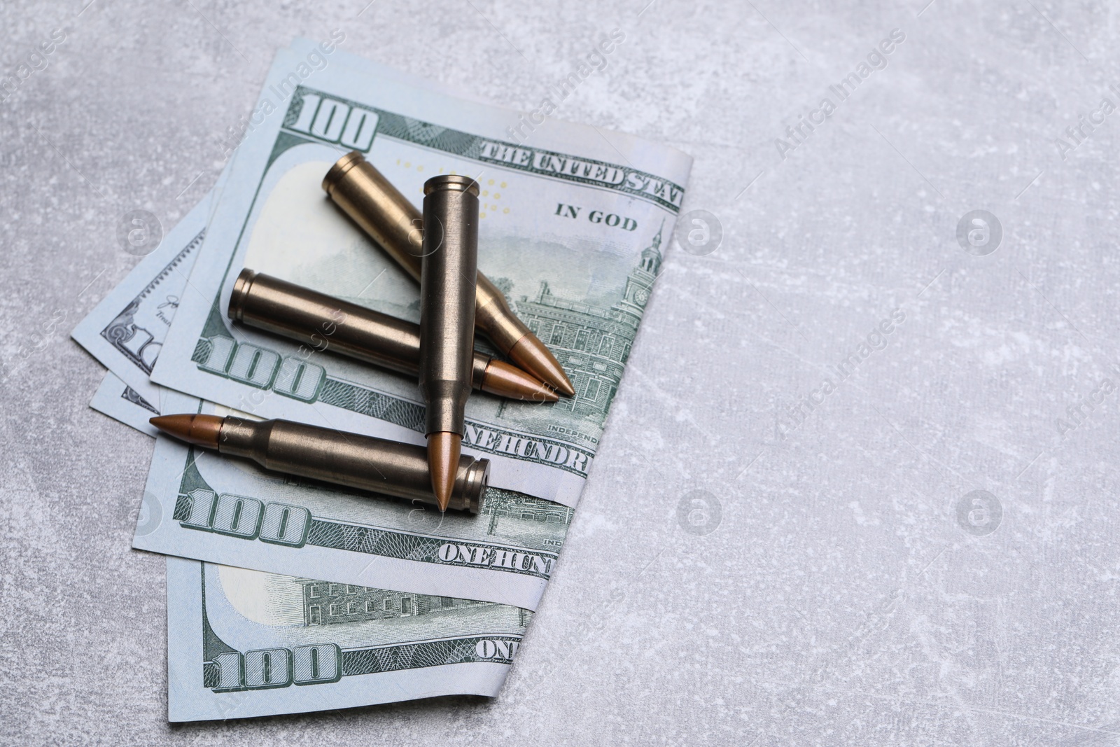 Bullets and dollars on grey table, flat lay. Space for text Photo of Bullets and dollars on grey table, flat lay. Space for text