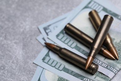 Photo of Bullets and dollars on grey table, closeup. Space for text