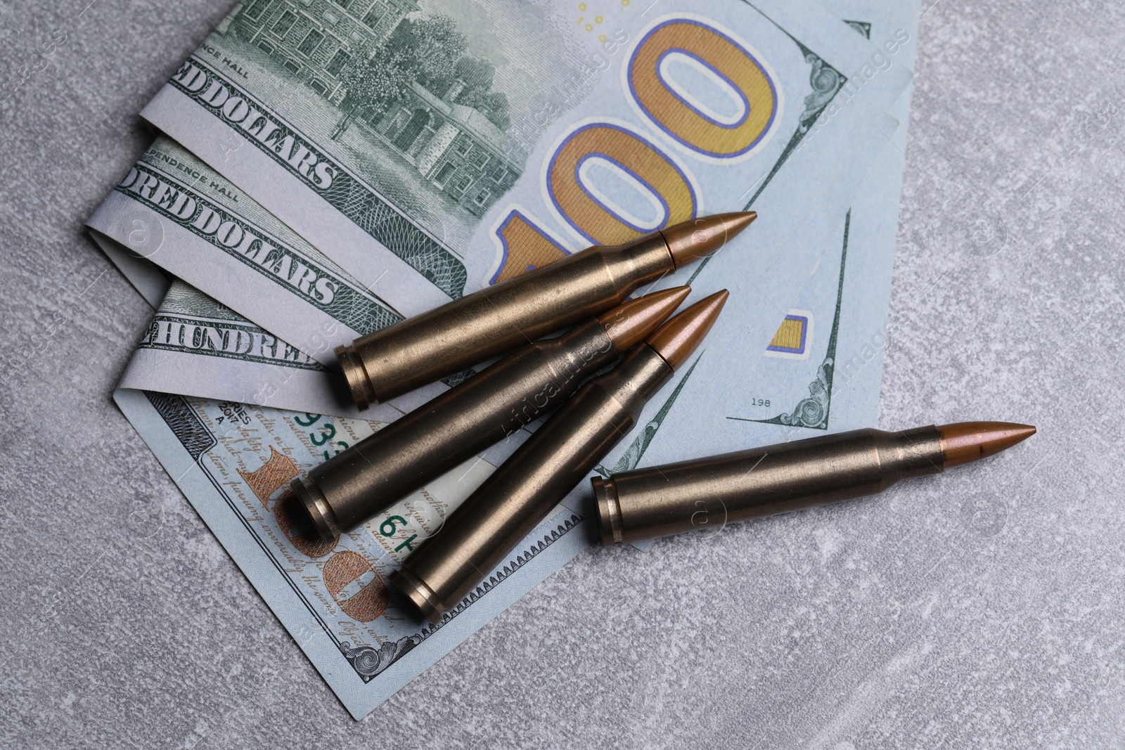 Bullets and dollars on grey table, flat lay Photo of Bullets and dollars on grey table, flat lay
