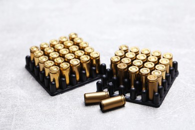 Photo of Many metal bullets on grey table, closeup
