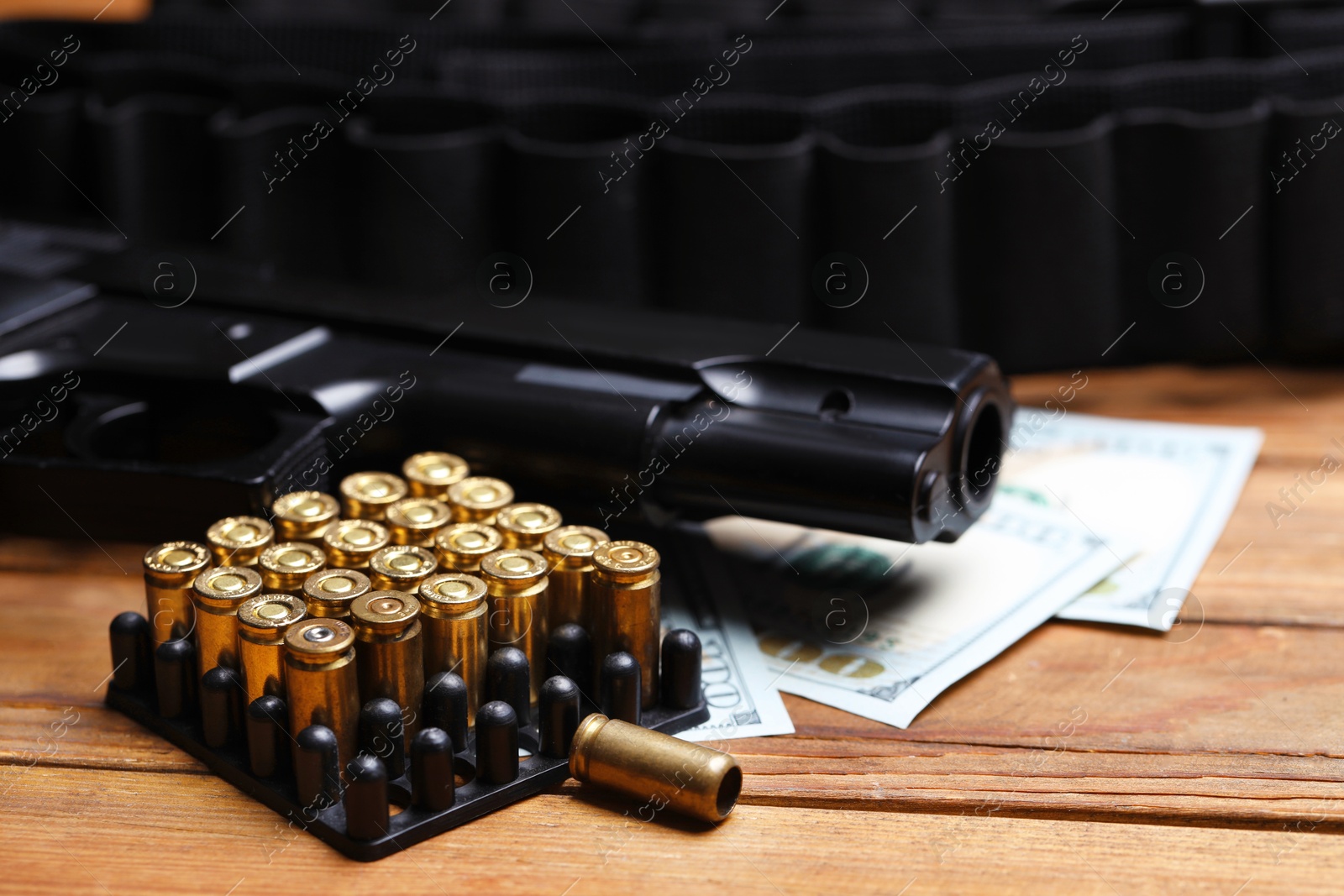 Bullets, gun, dollars and ammunition belt on wooden table, closeup Photo of Bullets, gun, dollars and ammunition belt on wooden table, closeup