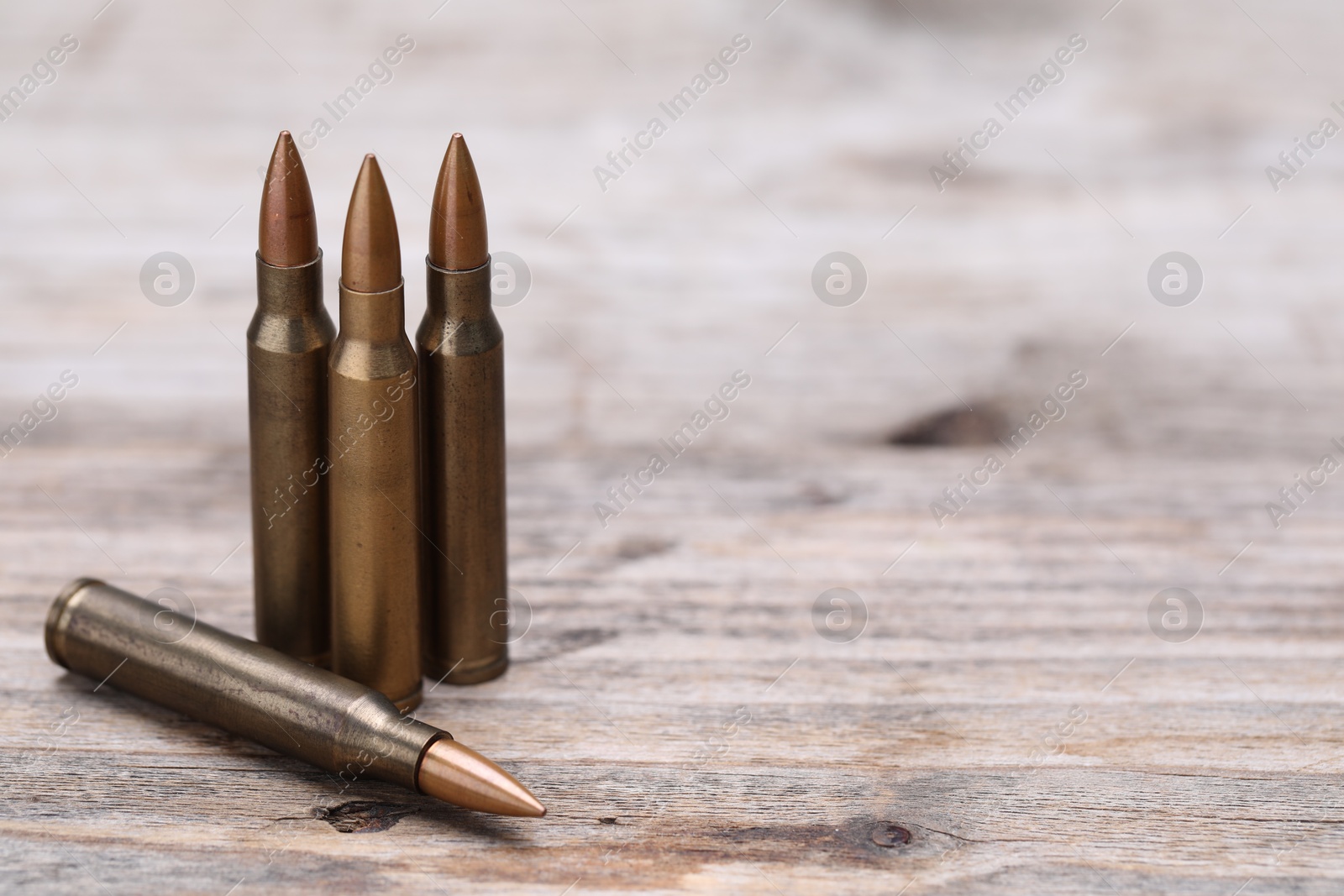Many metal bullets on wooden table, closeup. Space for text Photo of Many metal bullets on wooden table, closeup. Space for text