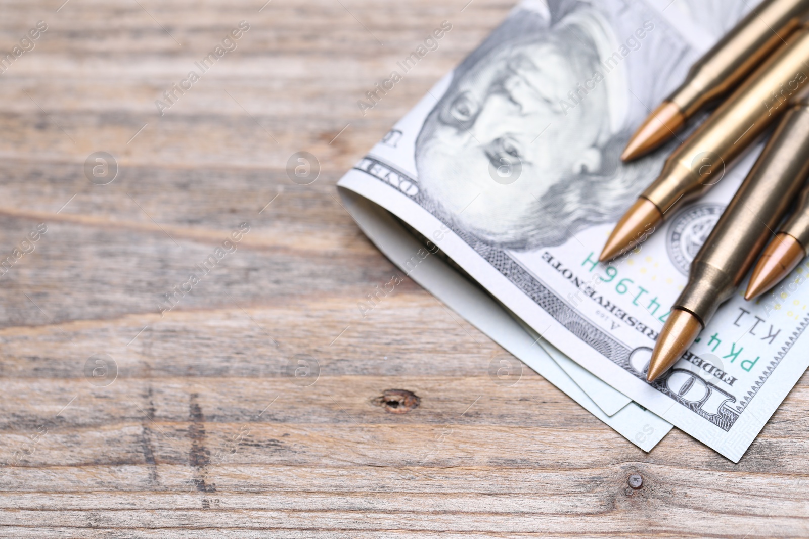 Bullets and dollars on wooden table, above view. Space for text Photo of Bullets and dollars on wooden table, above view. Space for text