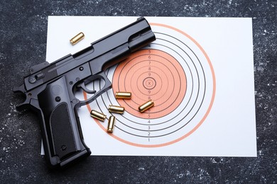 Photo of Many metal bullets, gun and shooting target on grey table, flat lay