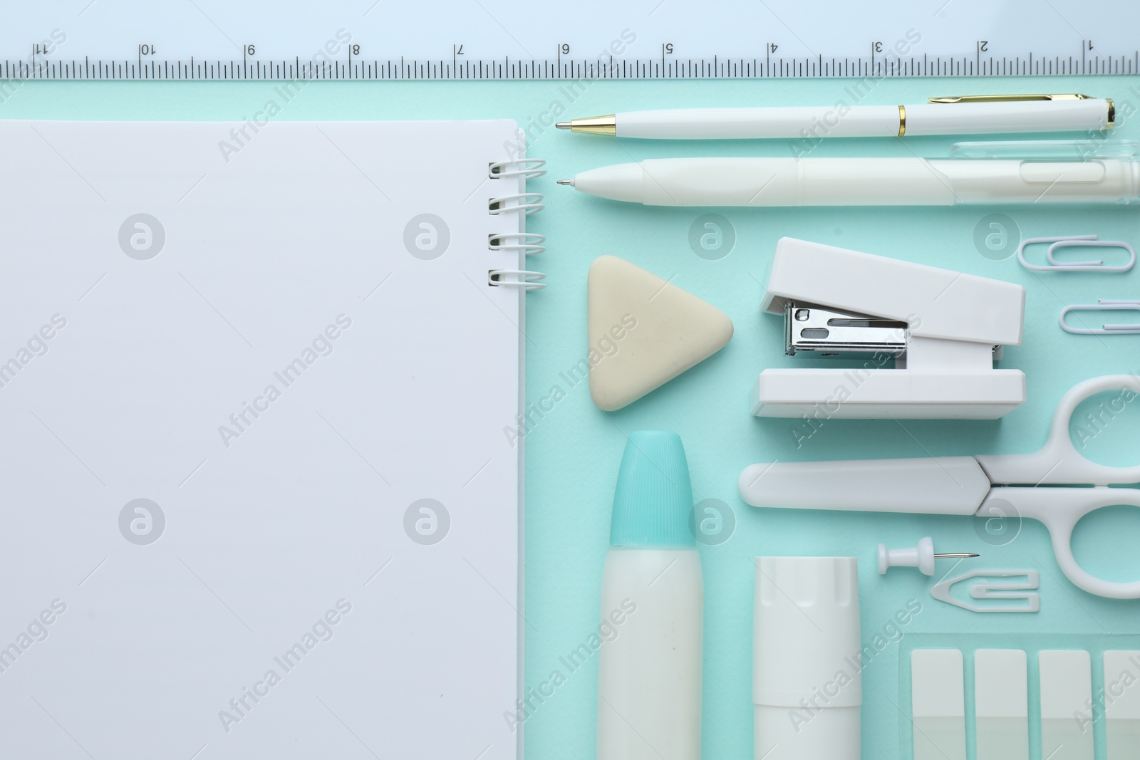 White notepad and other stationery on turquoise background, flat lay. Space for text Photo of White notepad and other stationery on turquoise background, flat lay. Space for text