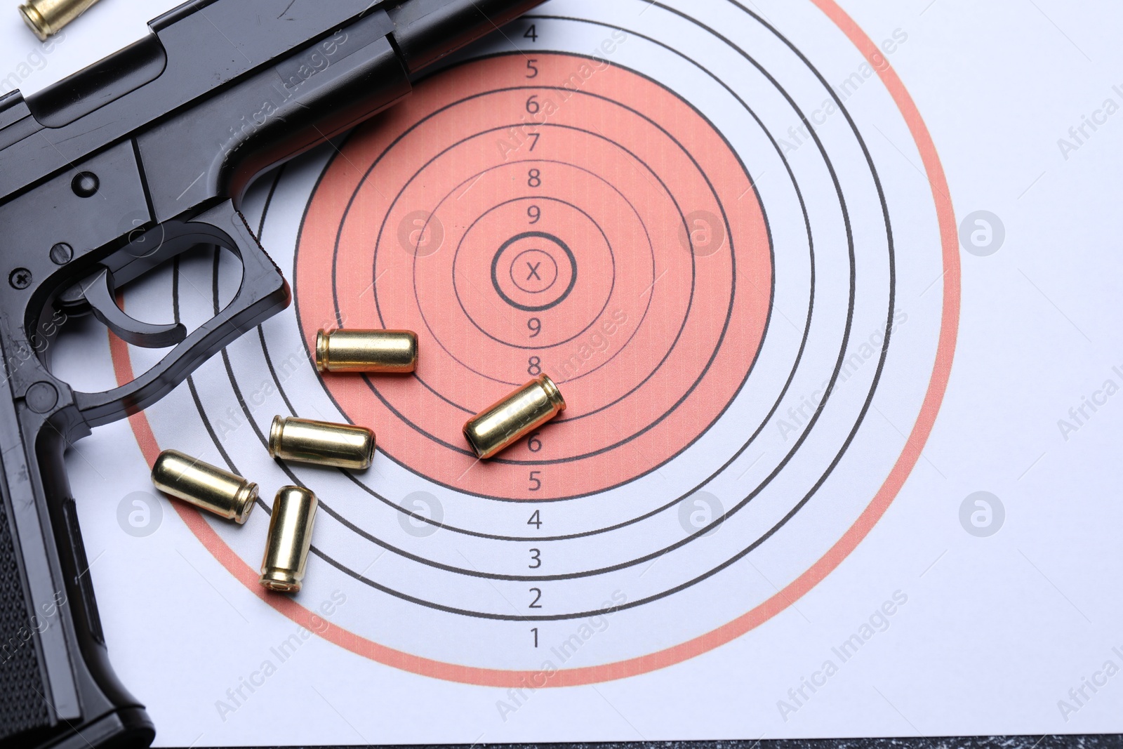 Many metal bullets and gun on shooting target, flat lay Photo of Many metal bullets and gun on shooting target, flat lay