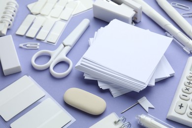 Photo of Different white stationery on violet background, closeup