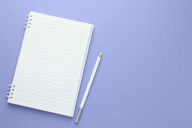 Photo of Open notepad and white pencil on violet background, flat lay. Space for text