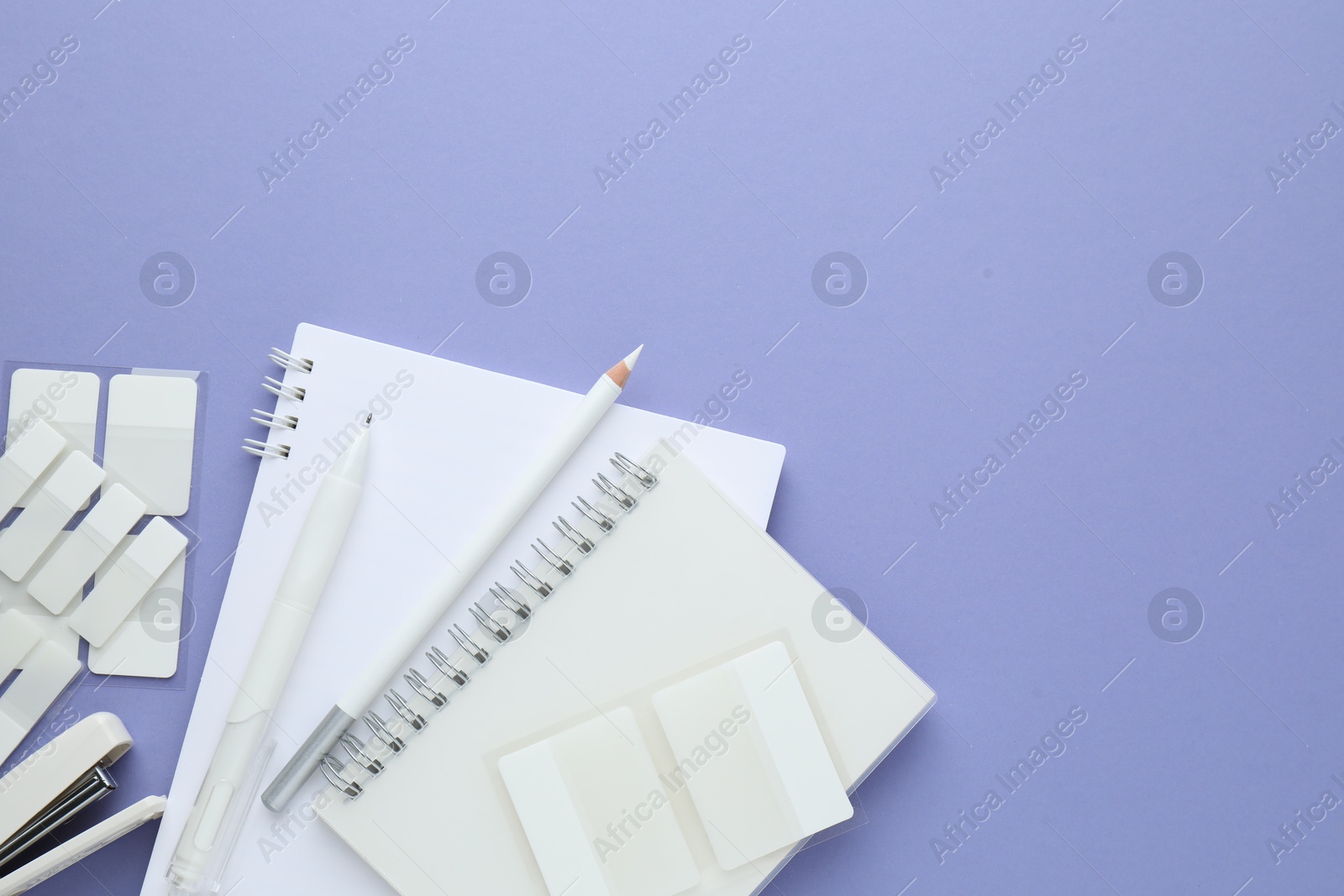Different white stationery on violet background, flat lay. Space for text Photo of Different white stationery on violet background, flat lay. Space for text