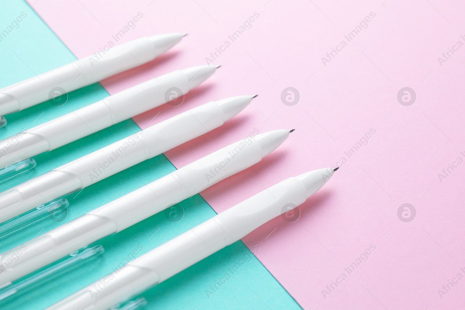 White pens on color background, closeup view Photo of White pens on color background, closeup view