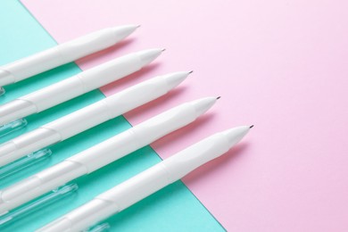 Photo of White pens on color background, closeup view