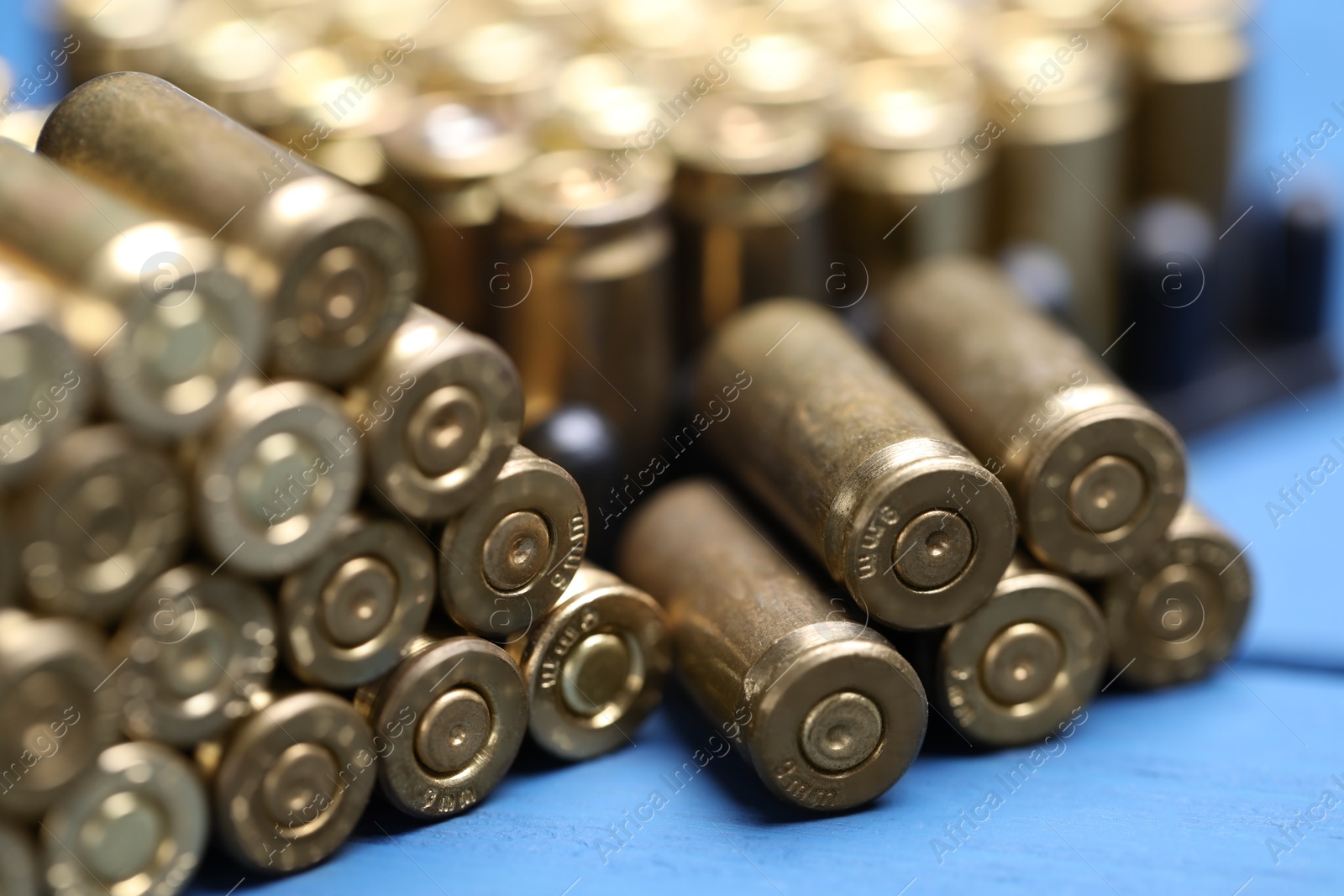 Stack of metal bullets on blue wooden table, closeup Photo of Stack of metal bullets on blue wooden table, closeup