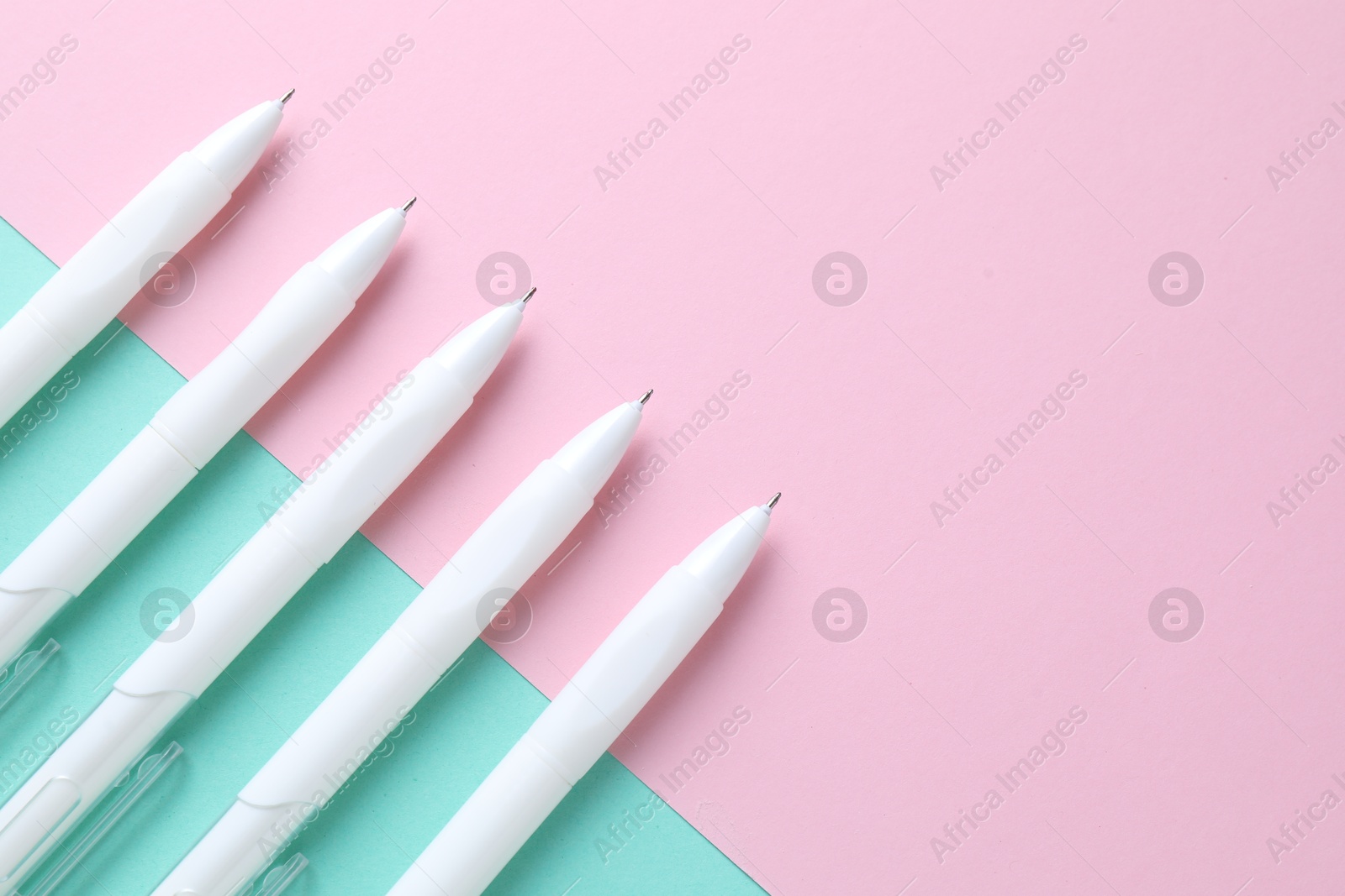 White pens on color background, flat lay. Space for text Photo of White pens on color background, flat lay. Space for text