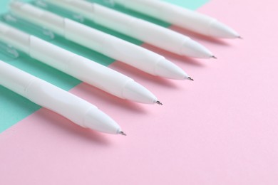 Photo of White pens on color background, closeup view