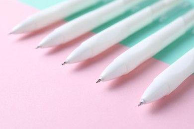 Photo of White pens on color background, closeup view