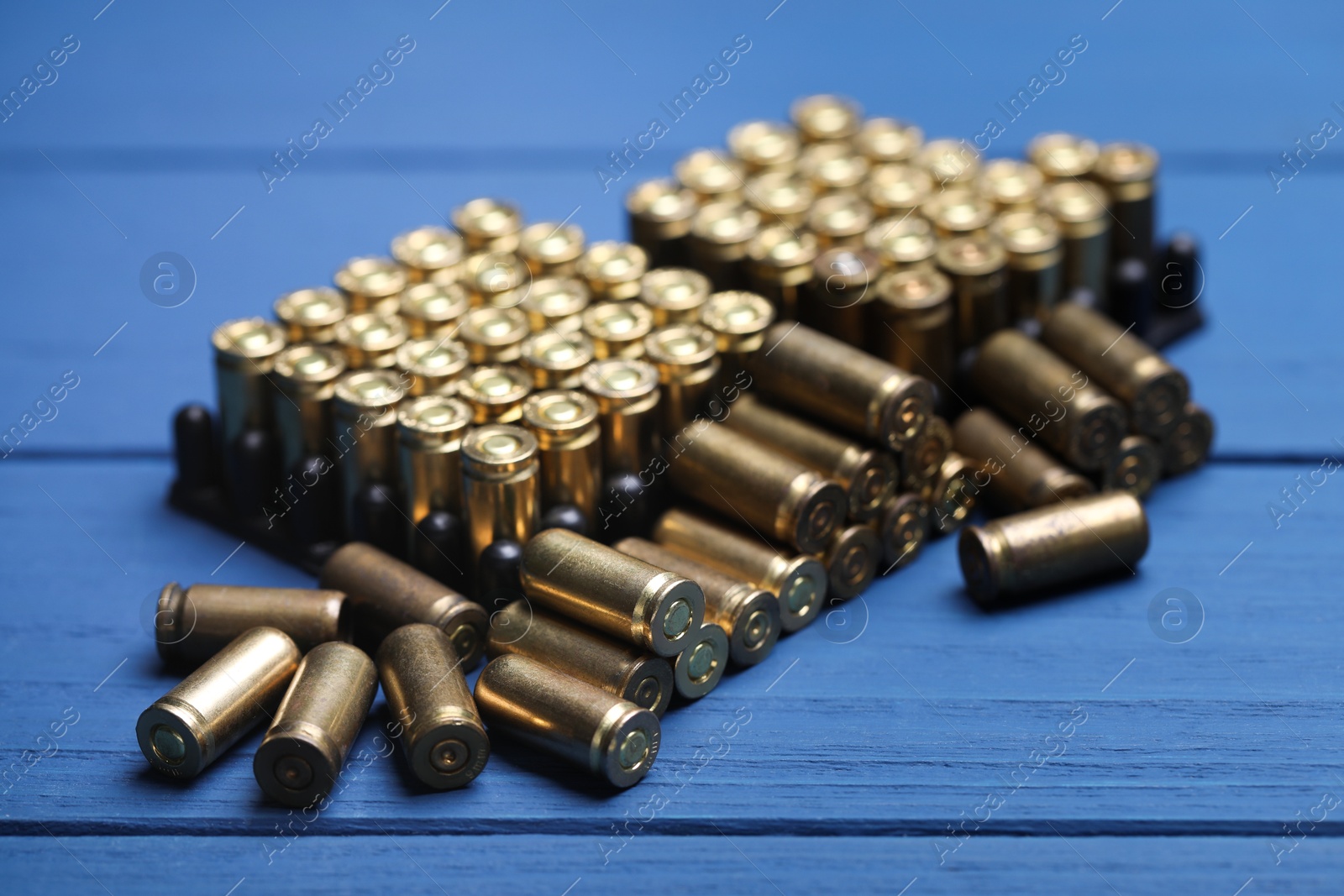 Many metal bullets on blue wooden table, closeup Photo of Many metal bullets on blue wooden table, closeup
