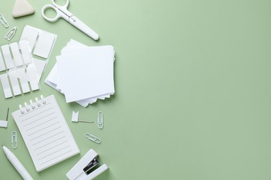 Photo of Different white stationery on light green background, flat lay. Space for text