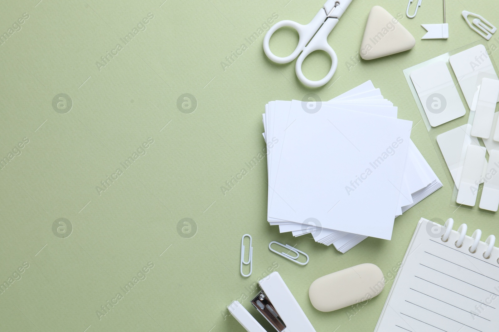 Different white stationery on light green background, flat lay. Space for text Photo of Different white stationery on light green background, flat lay. Space for text