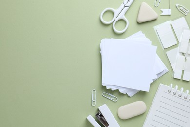 Photo of Different white stationery on light green background, flat lay. Space for text
