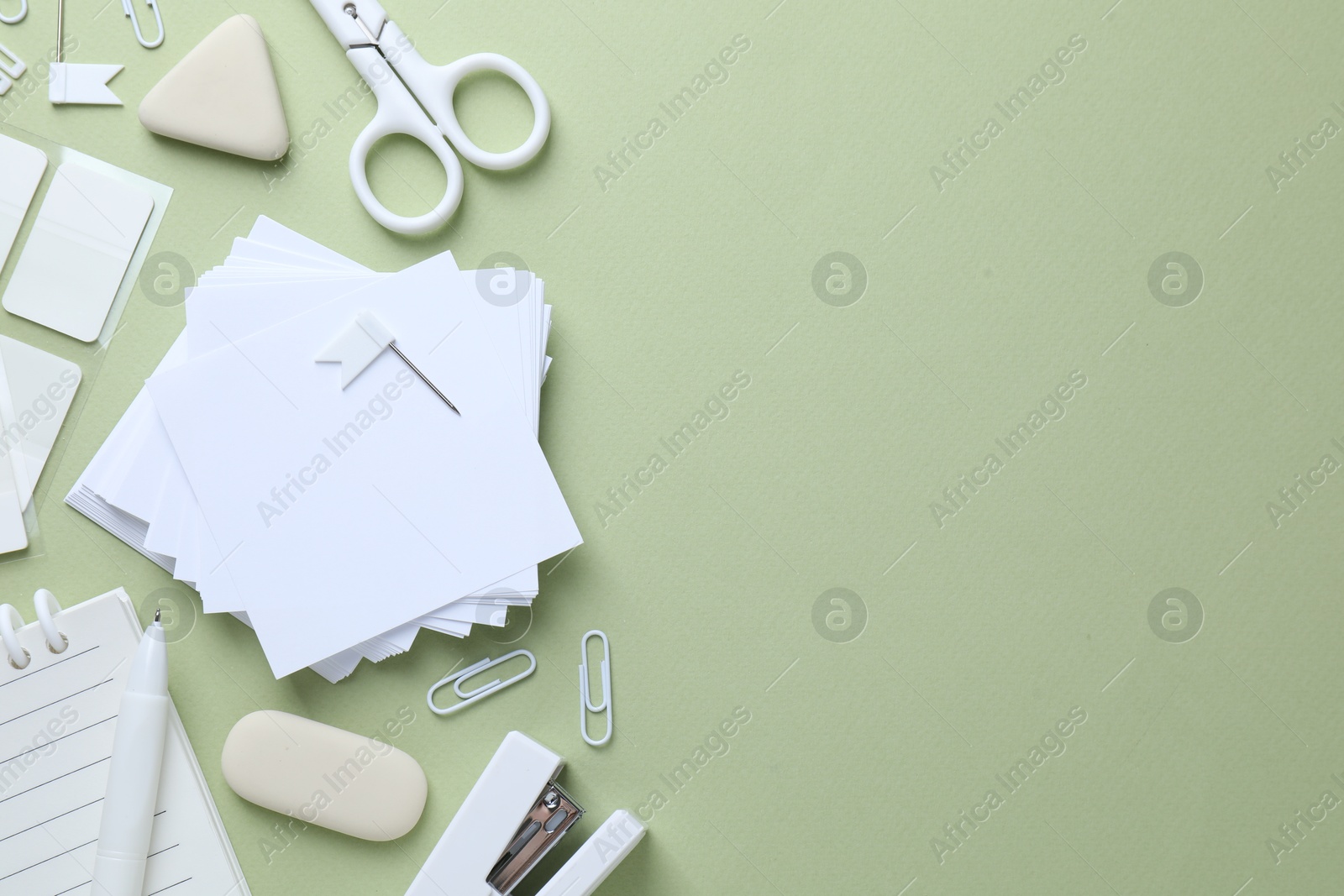 Different white stationery on light green background, flat lay. Space for text Photo of Different white stationery on light green background, flat lay. Space for text