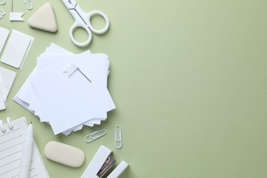 Photo of Different white stationery on light green background, flat lay. Space for text