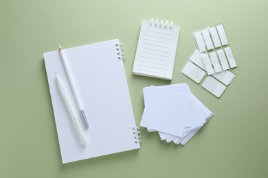 Photo of Different white stationery on light green background, flat lay