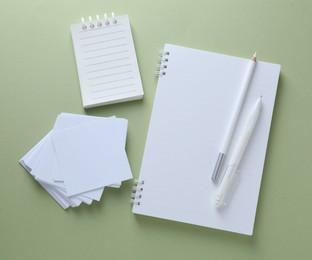 Photo of Different white stationery on light green background, flat lay