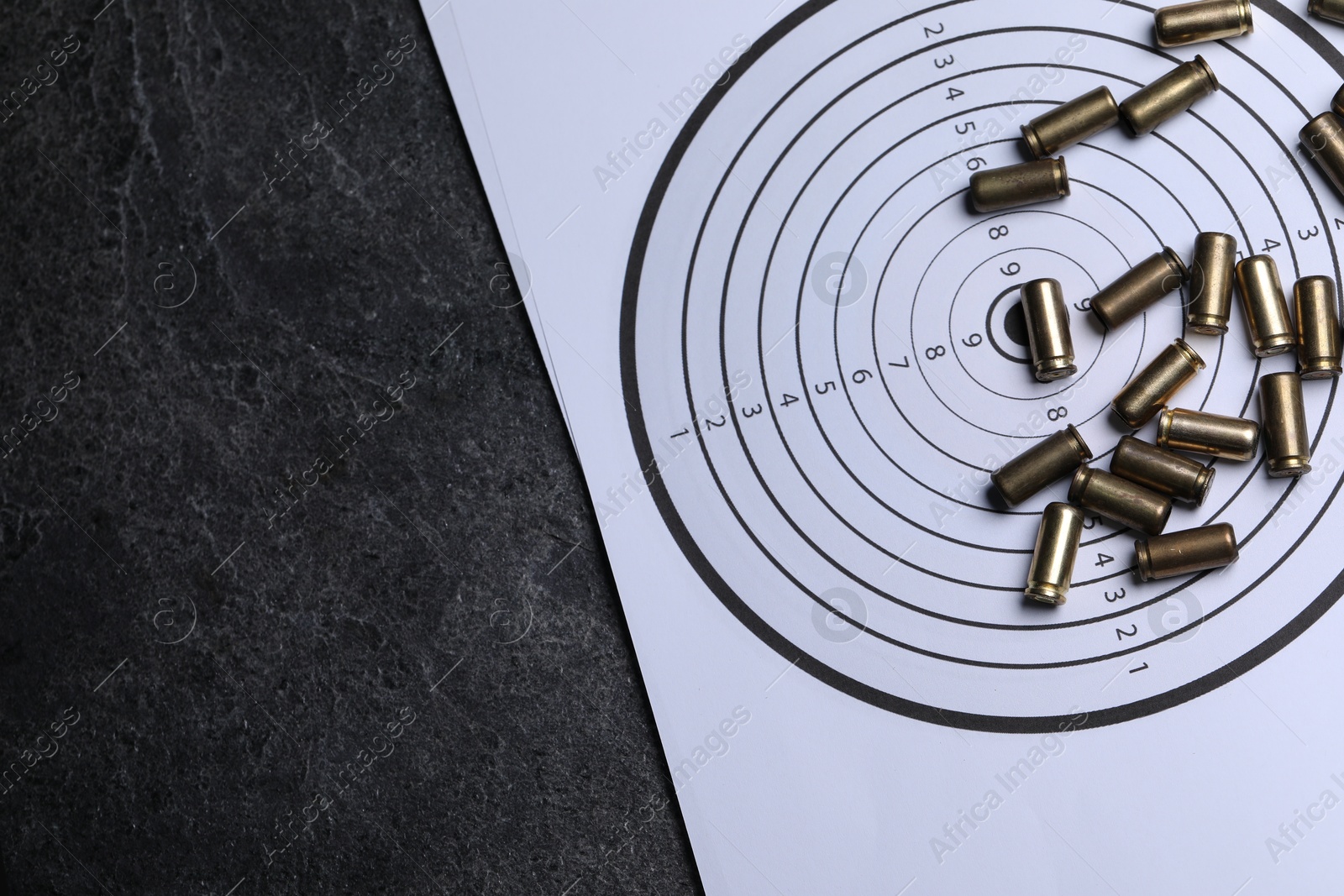 Metal bullets and shooting target on grey table, top view. Space for text Photo of Metal bullets and shooting target on grey table, top view. Space for text