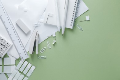 Photo of Different white stationery on light green background, flat lay. Space for text