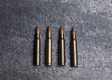 Photo of Many metal bullets on grey table, flat lay