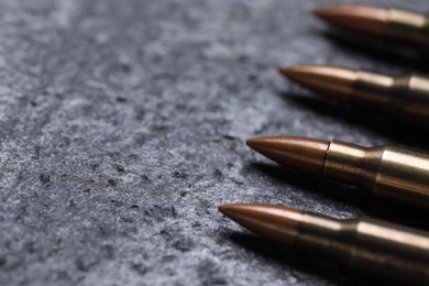 Photo of Many metal bullets on grey table, closeup. Space for text