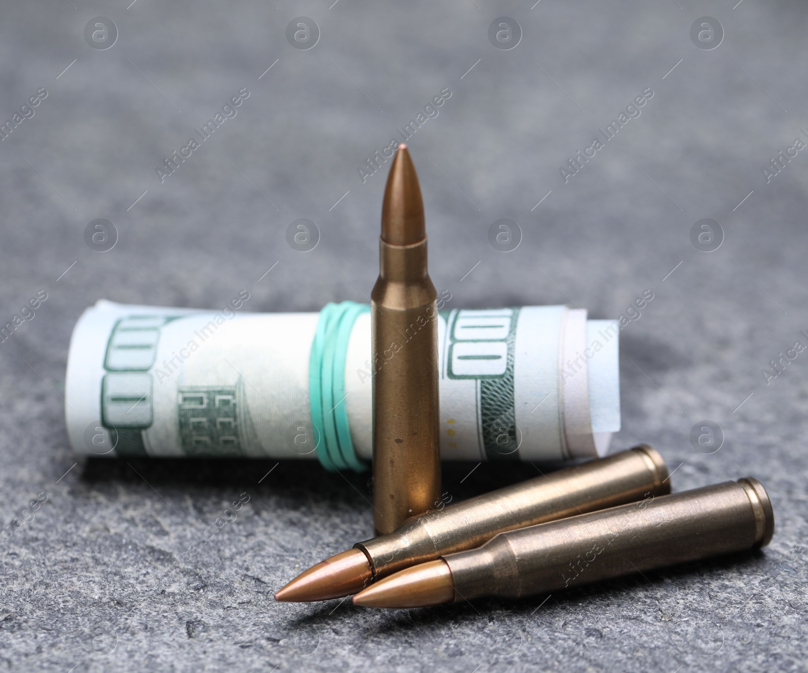 Bullets and dollars on grey table, closeup Photo of Bullets and dollars on grey table, closeup